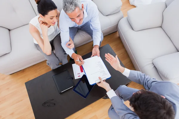 Salesman showing contract to couple who are about to sign — Stock Photo, Image