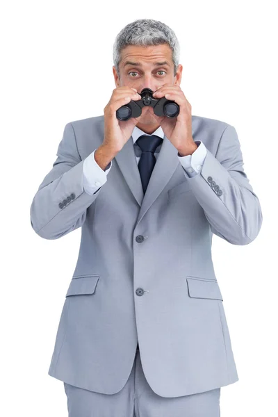 Homem de negócios curioso observando com binóculos — Fotografia de Stock