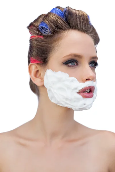 Modello pensieroso in bigodini per capelli con schiuma da barba — Foto Stock