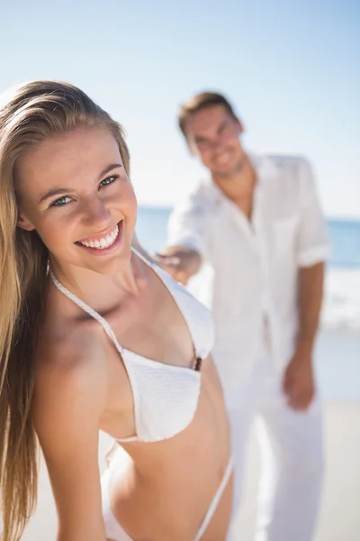 Blonde woman smiling at camera with boyfriend holding her hand — Stock Photo, Image