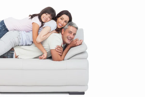 Lächelndes kleines Mädchen liegt auf dem Sofa ihrer Eltern — Stockfoto