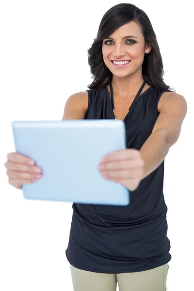 Sorrindo elegante modelo de cabelos escuros segurando seu tablet — Fotografia de Stock