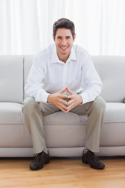 Young man sitting on sofa — Stock Photo, Image