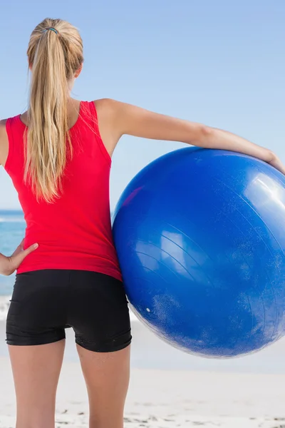 Apto loira segurando bola de exercício olhando para o oceano — Fotografia de Stock