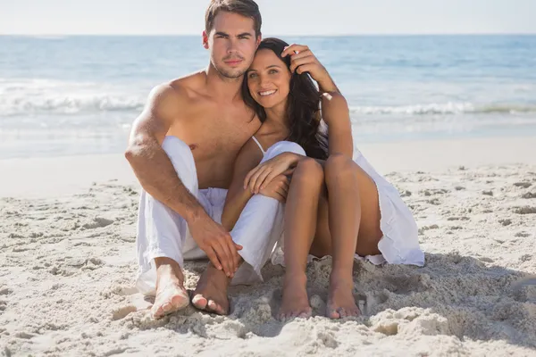 Cuddling couple smiling at camera — Stock Photo, Image