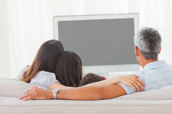 Семья смотрит телевизор вместе на диване — стоковое фото