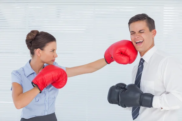 Affärskvinna stansning hennes kollega medan boxning tillsammans — Stockfoto