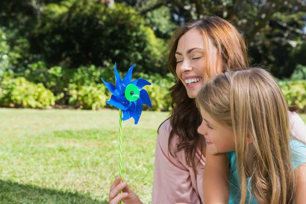 Moeder met dochter met een pinwheel in het park — Stockfoto