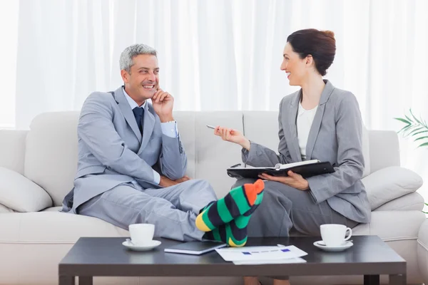 Funny businessman wearing stripey socks and laughing with his co — Stock Photo, Image
