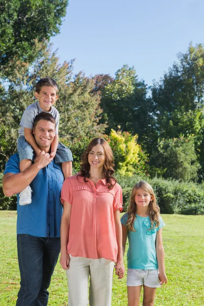 Young family posing in a park — Stock Photo, Image