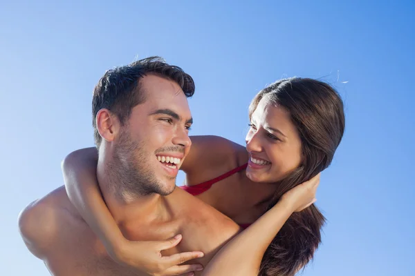 Bonito homem carregando sua namorada de costas — Fotografia de Stock