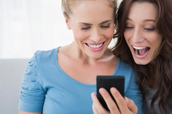 Cheerful friends reading message on their phone — Stock Photo, Image