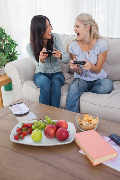 Cheerful friends playing video games and laughing — Stock Photo, Image