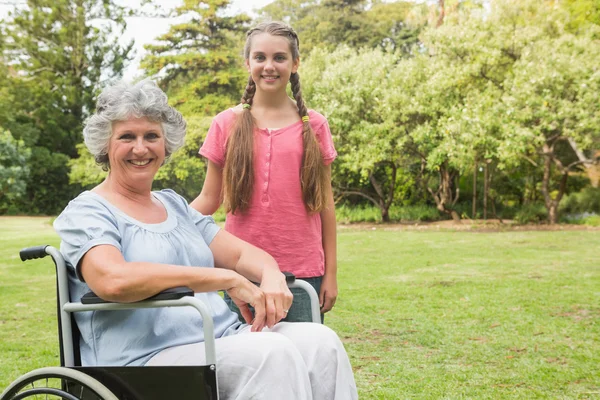 Cute granddaughter with grandmother in her wheelchair — Stock Photo, Image