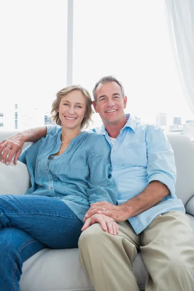Mellersta åldern paret sitter i soffan — Stockfoto