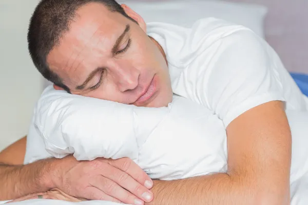 抱着他的枕头在睡觉的人 — 图库照片