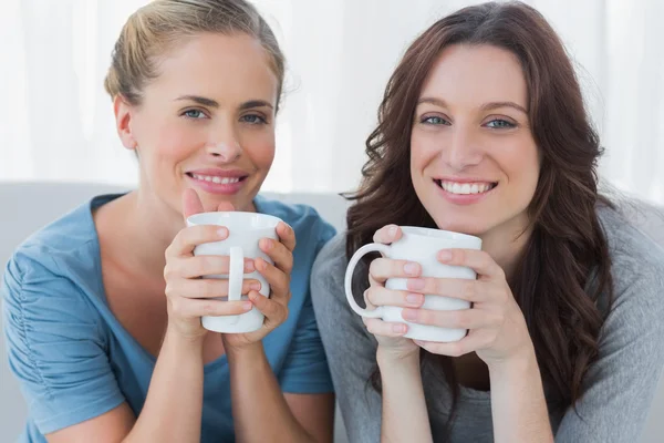 Friends having coffee and looking at camera — Stock Photo, Image