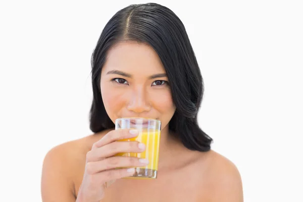 Чувственная обнаженная модель пьет апельсиновый сок — стоковое фото