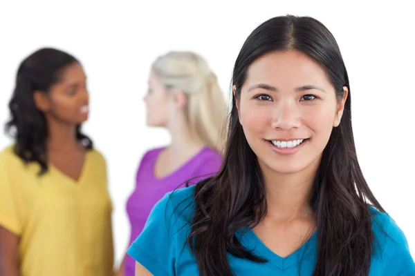 Smiling asian woman looking at camera with two women behind her — Stock Photo, Image