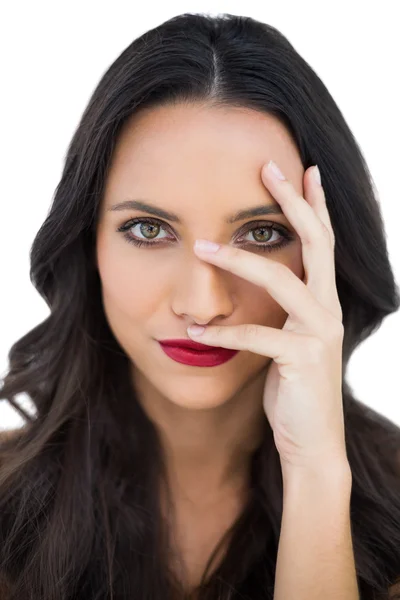 Femme aux cheveux foncés avec des lèvres rouges cachant son visage — Photo