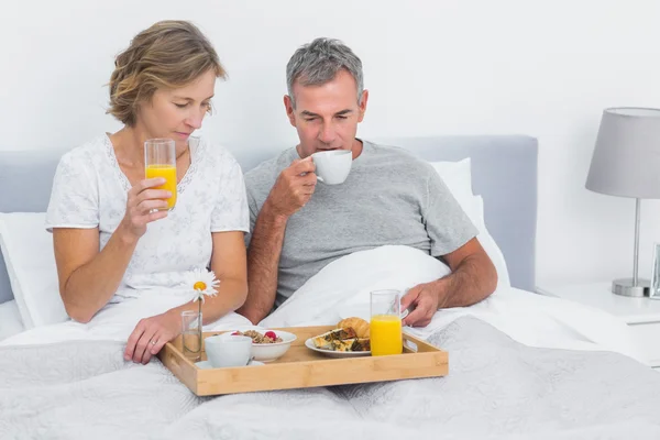 一緒にベッドで朝食を楽しんで幸せなカップル — ストック写真