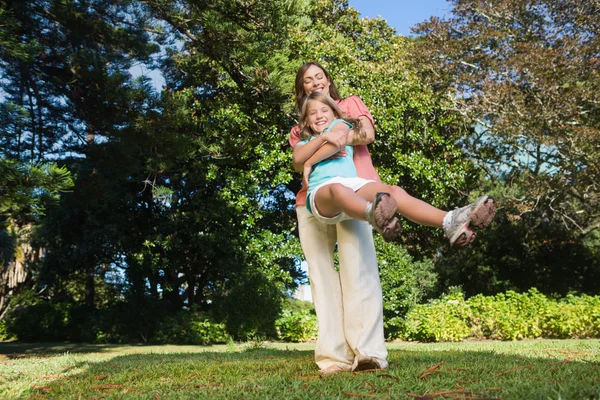 Mother swinging her daughter around having fun — Stock Photo, Image