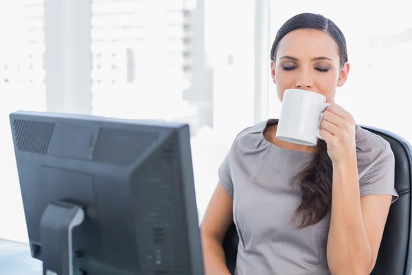 Lächelnde attraktive Geschäftsfrau trinkt Tee — Stockfoto