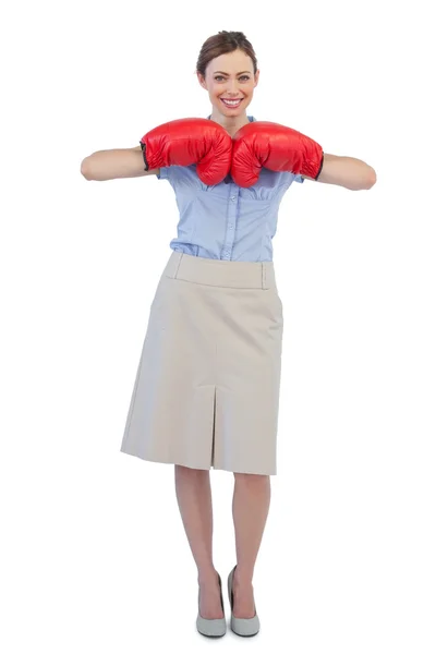 Mujer de negocios alegre posando con guantes de boxeo rojos — Foto de Stock