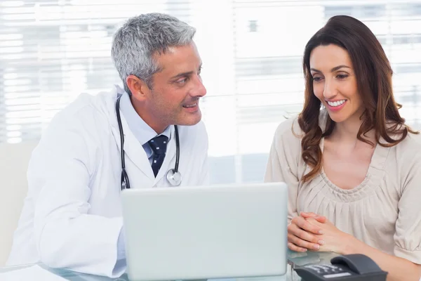 Docter showing something on laptop to his patient — Stock Photo, Image