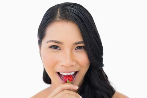 Atractivo modelo de pelo castaño comiendo fresa — Foto de Stock