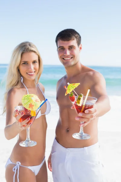 Attraktives junges Paar lächelt mit Cocktails in die Kamera — Stockfoto