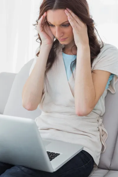 Nervózní brunetka pracuje na svém laptopu — Stock fotografie