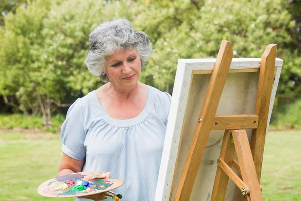 Content mature woman painting on canvas — Stock Photo, Image