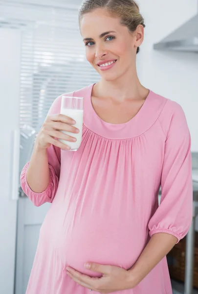 Vrolijke verwachten vrouw consumptiemelk — Stockfoto