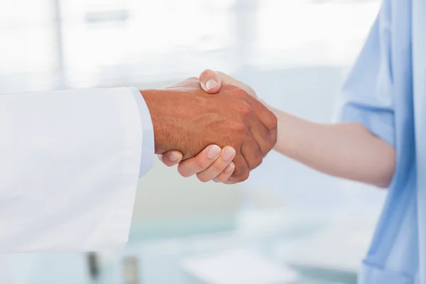 Hands of a doctor and nurse shaking hands — Stock Photo, Image