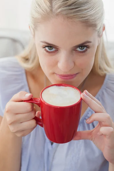 Blonde holding a mug and smiling at camera — Stock Photo, Image