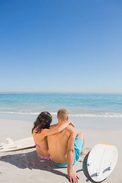 Bonito jovem casal sentado com suas pranchas de surf — Fotografia de Stock