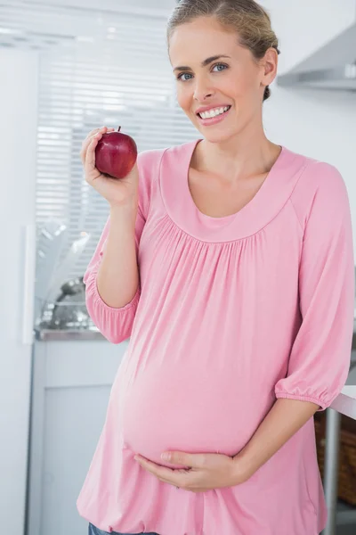 Expecting woman holding apple — Stock Photo, Image