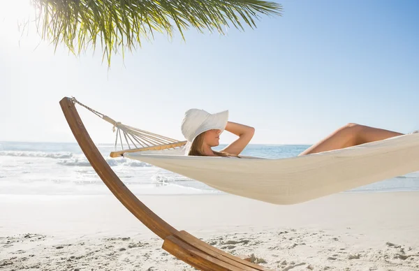 Mulher usando chapéu de sol e biquíni relaxante na rede — Fotografia de Stock