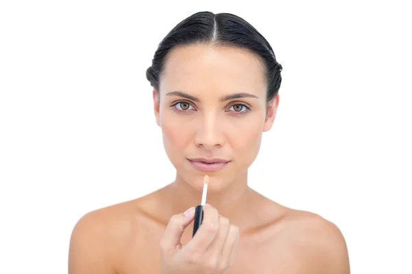 Serious young brunette making up — Stock Photo, Image