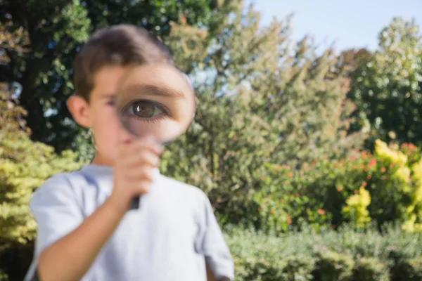 Мальчик держит увеличительное стекло — стоковое фото