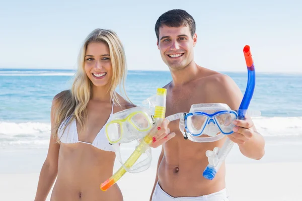 Attractive couple showing snorkels and goggles to camera — Stock Photo, Image