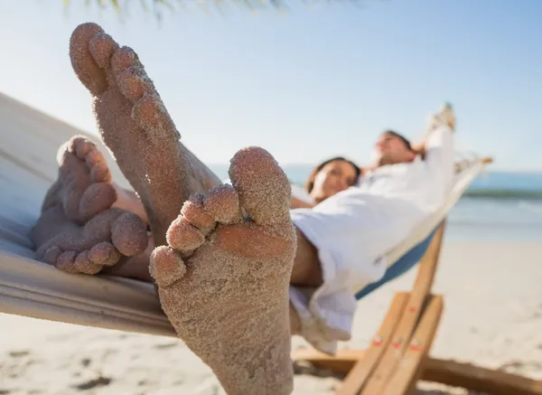 Close up of sandy feet of couple in a hammock — Stock Photo, Image