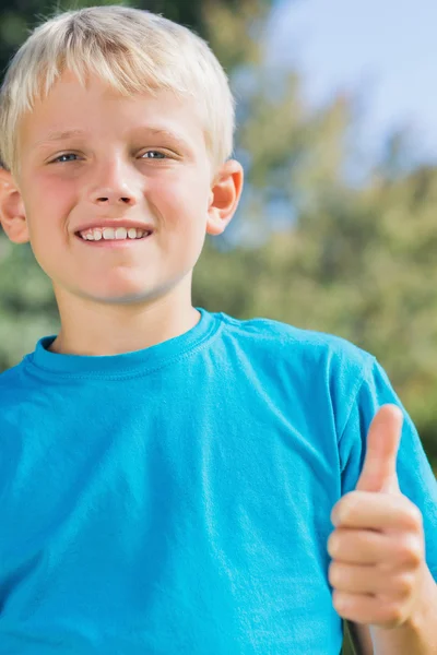 Lilla blonda pojken ler mot kameran ger tummen upp — Stockfoto