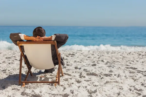 Young businessman relaxing on his sun lounger — Stok fotoğraf