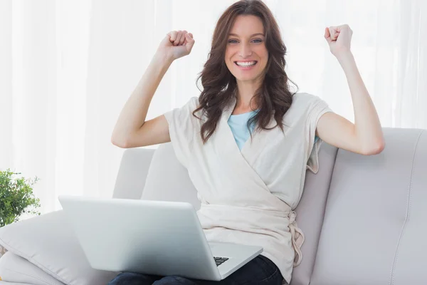 Juichende vrouw met laptop op haar knieën — Stockfoto