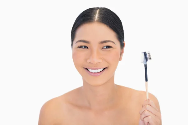 Smiling natural brunette holding eyebrow brush — Stock Photo, Image