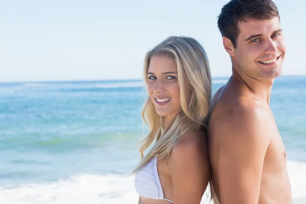 Young smiling couple standing back to back — Stock Photo, Image