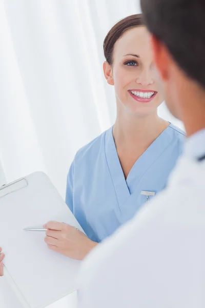 Alegre bonita cirujana hablando con un médico —  Fotos de Stock