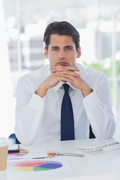 Hombre de negocios serio posando cruzando dedos Fotos de stock libres de derechos